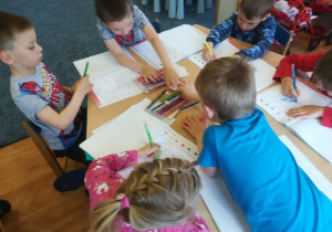 Dzieci przy stolikach kolorują bukiet wg podanego kodu.